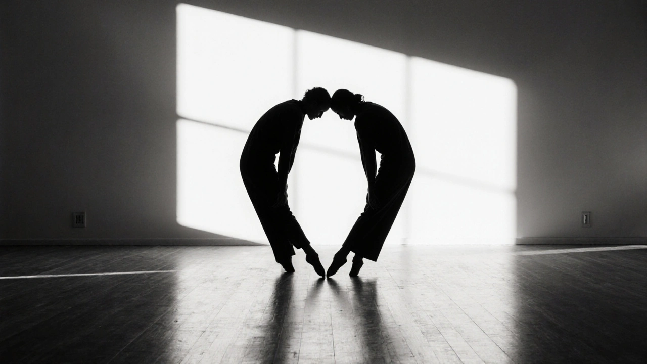 Yüksek kontrastlı siyah-beyaz bir fotoğraf: iki figür, birbirini aynalayan yavaş dans hareketleriyle siluet halinde.